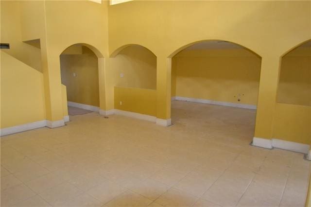 4682 Perrault Walk, New Orleans, LA 70127 - tiled spare room with arched walkways and a towering ceiling