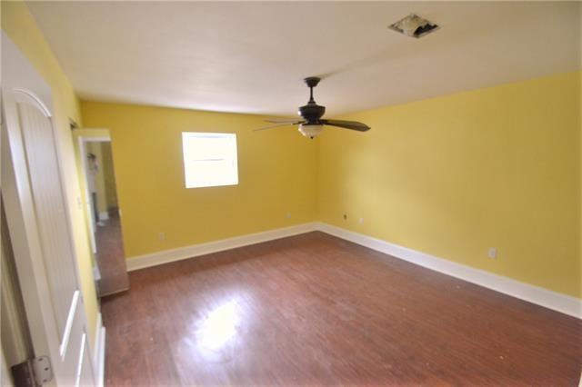 4682 Perrault Walk, New Orleans, LA 70127 - unfurnished room with a ceiling fan, dark wood-style floors, and baseboards