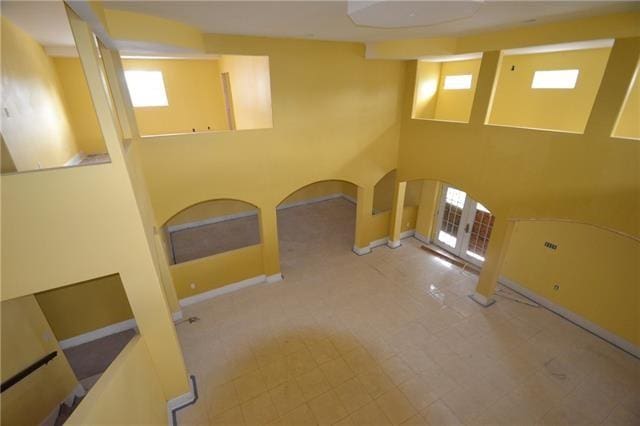 interior space with tile patterned flooring, plenty of natural light, and a high ceiling