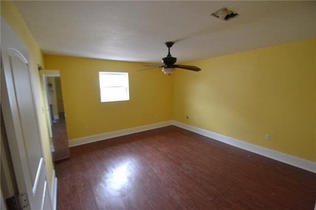 empty room featuring ceiling fan and dark hardwood / wood-style flooring