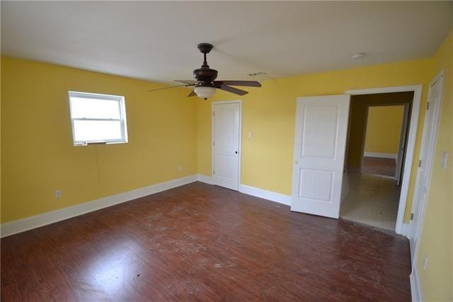 unfurnished bedroom featuring dark hardwood / wood-style floors and ceiling fan