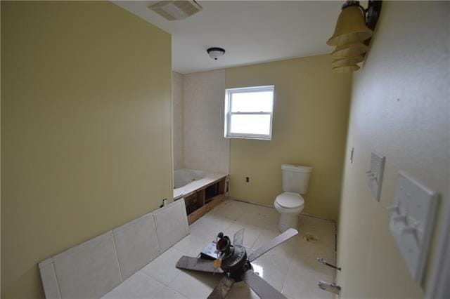 bathroom with toilet, tile patterned flooring, and a bathing tub