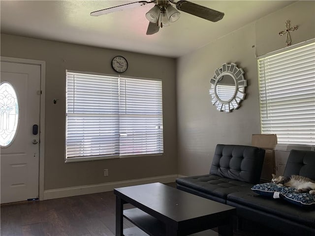 living room featuring dark wood-type flooring, plenty of natural light, and ceiling fan