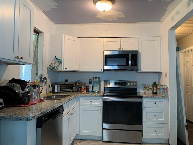 kitchen with appliances with stainless steel finishes, white cabinets, and sink