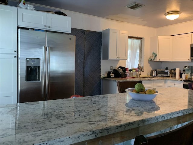 kitchen featuring sink, light stone countertops, white cabinets, and stainless steel appliances