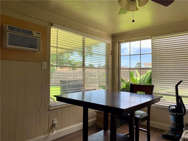 dining space featuring a wall unit AC, ceiling fan, and hardwood / wood-style flooring