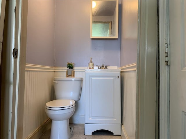 bathroom with toilet, vanity, and tile patterned flooring