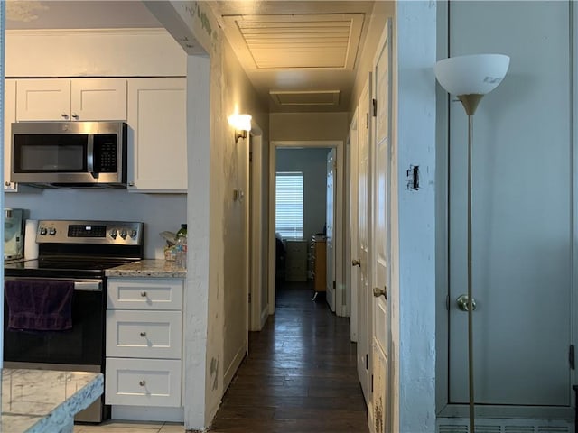 kitchen featuring dark wood-type flooring, stainless steel appliances, and white cabinetry