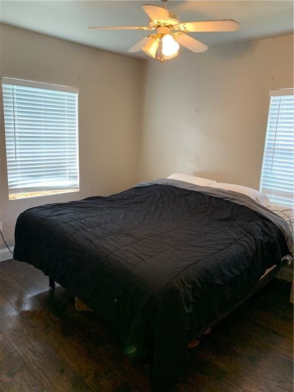 bedroom with ceiling fan and dark hardwood / wood-style flooring