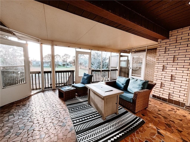 sunroom with an outdoor living space and beamed ceiling