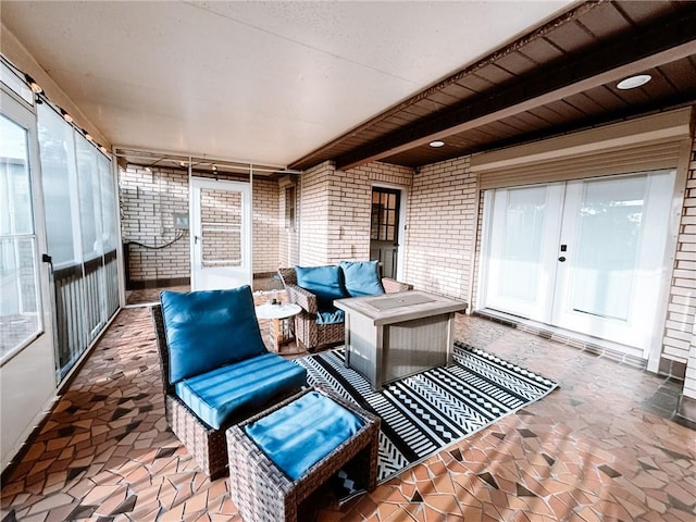 sunroom featuring beam ceiling, french doors, and an outdoor hangout area