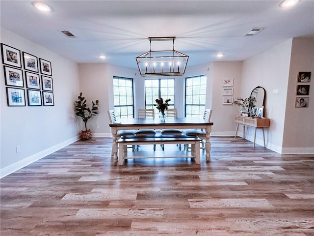 dining space with recessed lighting, wood finished floors, and visible vents