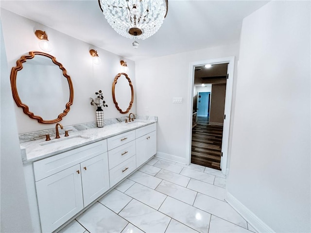 bathroom featuring a notable chandelier, double sink vanity, and wood-type flooring