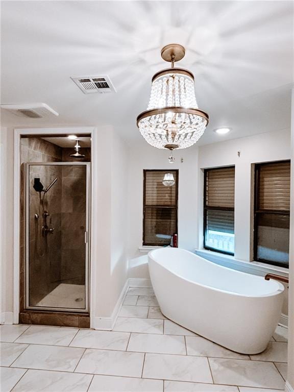 bathroom featuring tile patterned floors, shower with separate bathtub, and a chandelier