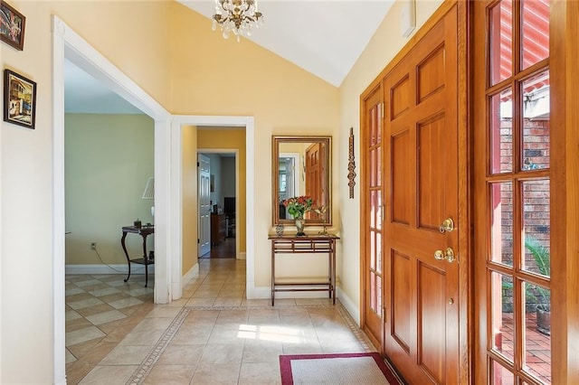 foyer featuring an inviting chandelier, light tile patterned floors, and vaulted ceiling