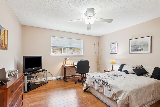 bedroom featuring a textured ceiling, light hardwood / wood-style flooring, and ceiling fan