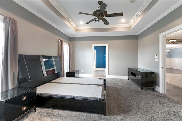 carpeted bedroom featuring a tray ceiling, ceiling fan, and crown molding