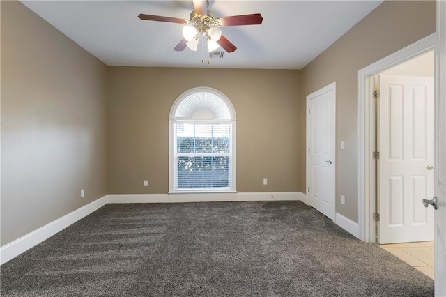 carpeted spare room featuring ceiling fan