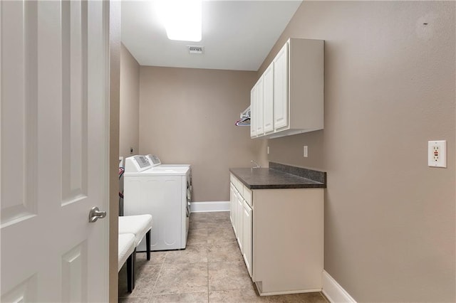 washroom featuring cabinets, light tile patterned floors, and washing machine and dryer