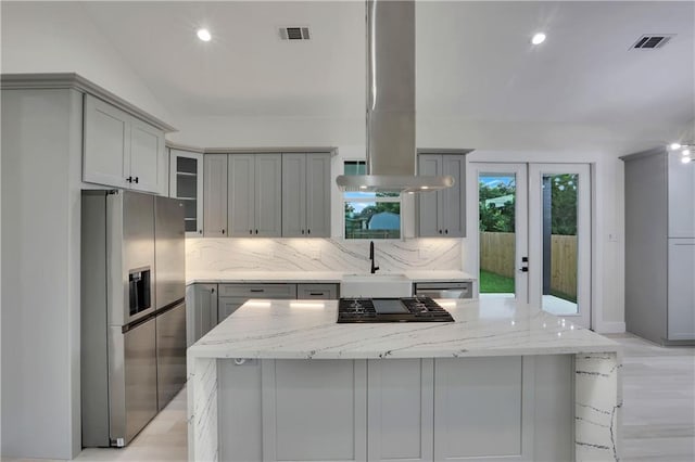 kitchen featuring light stone counters, gray cabinetry, and stainless steel appliances