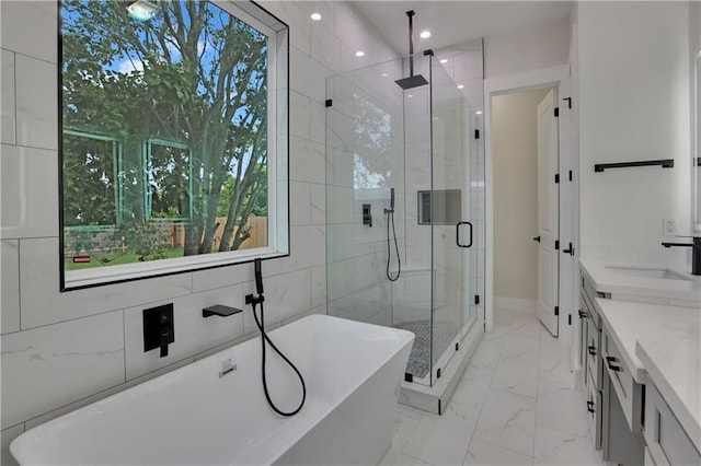 bathroom with separate shower and tub, vanity, and a wealth of natural light