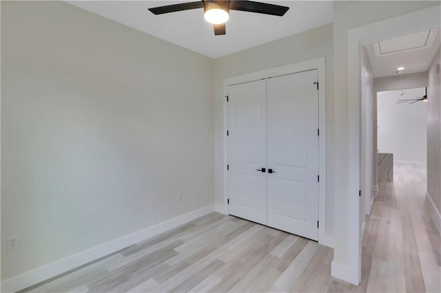 unfurnished bedroom featuring ceiling fan, a closet, and light hardwood / wood-style flooring