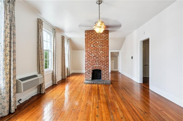 unfurnished living room with a fireplace, wood-type flooring, ceiling fan, and vaulted ceiling