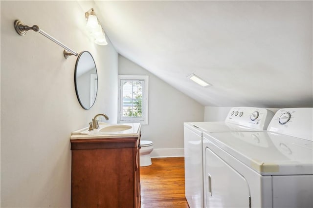 laundry room featuring wood-type flooring, sink, and washer and dryer