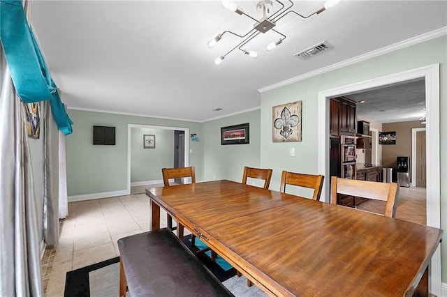 dining space featuring ornamental molding and light tile patterned floors