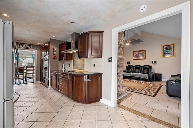 kitchen with stainless steel refrigerator, lofted ceiling with beams, ceiling fan, wall chimney exhaust hood, and light tile patterned flooring