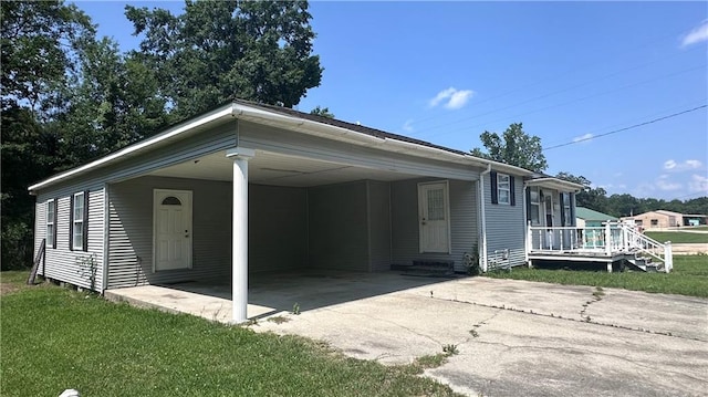 view of front of property with a carport and a front lawn