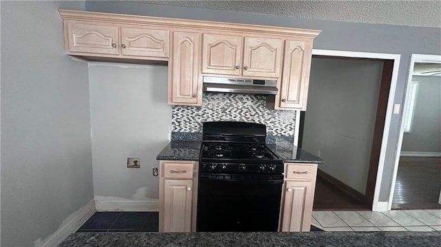 kitchen with backsplash, tile patterned floors, light brown cabinets, and black gas stove