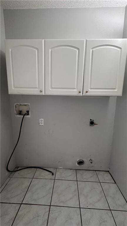 laundry room featuring gas dryer hookup, light tile patterned flooring, hookup for an electric dryer, cabinets, and washer hookup