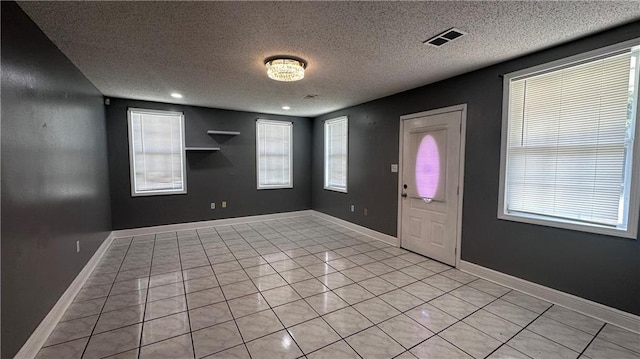 tiled foyer entrance with a textured ceiling