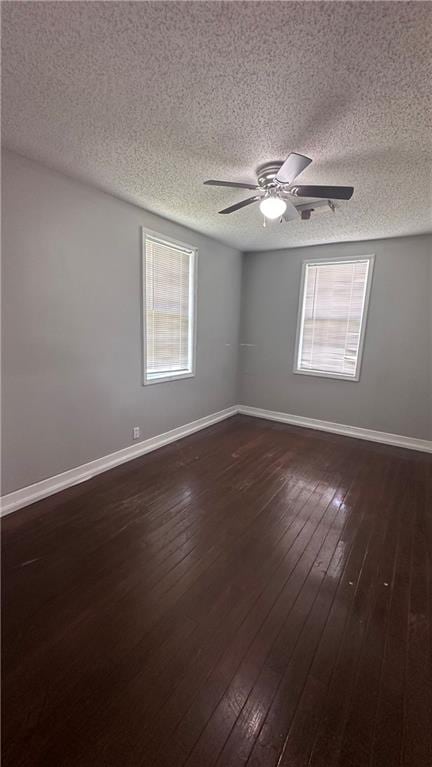 spare room featuring a wealth of natural light, ceiling fan, and hardwood / wood-style floors