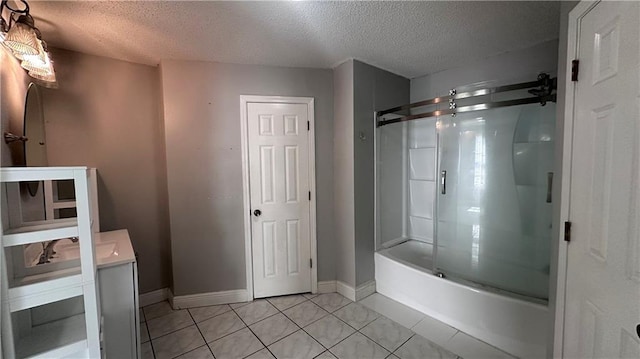 bathroom featuring tile patterned flooring, bath / shower combo with glass door, vanity, and a textured ceiling