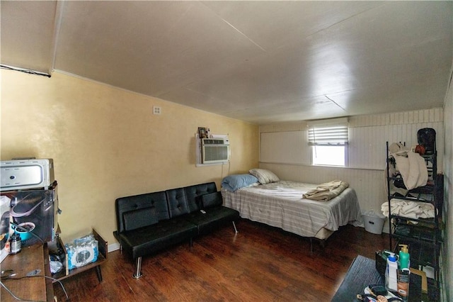 bedroom featuring hardwood / wood-style flooring and a wall unit AC