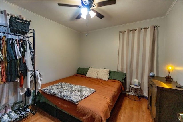 bedroom featuring light hardwood / wood-style flooring, ornamental molding, and ceiling fan