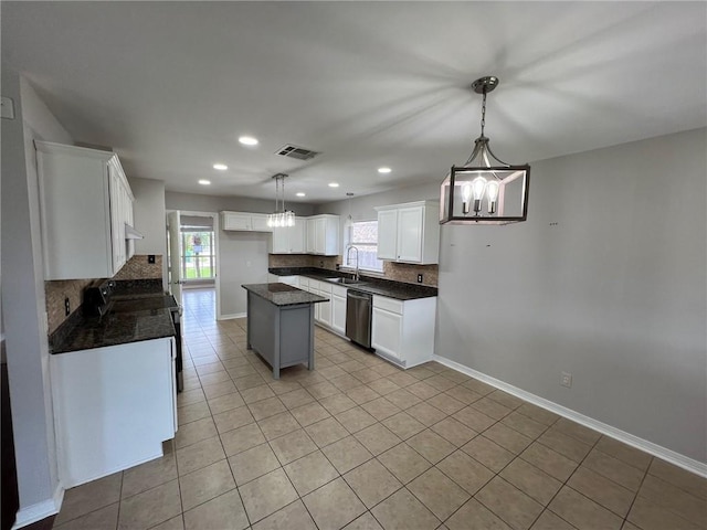 kitchen with light tile patterned floors, a sink, dishwasher, a notable chandelier, and backsplash