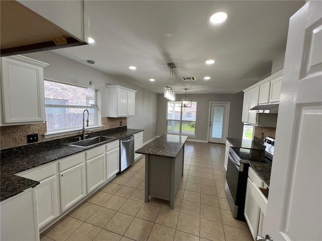 kitchen featuring electric range, visible vents, a sink, tasteful backsplash, and stainless steel dishwasher