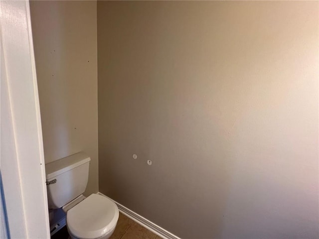 bathroom with tile patterned flooring, toilet, and baseboards