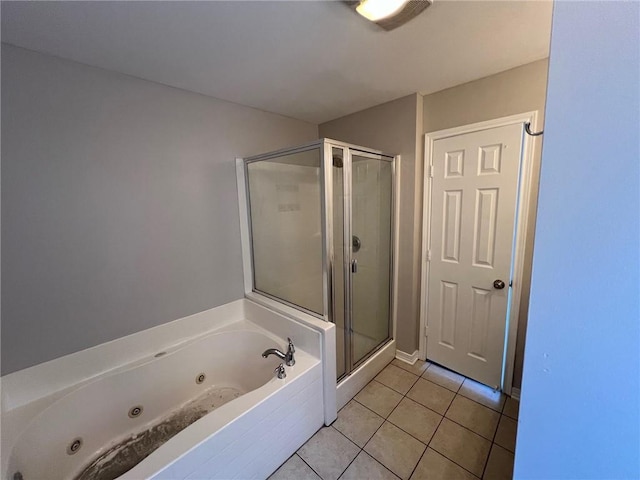 bathroom featuring tile patterned floors, a tub with jets, and a stall shower