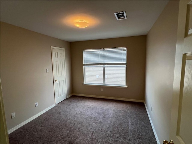 empty room featuring visible vents, baseboards, and carpet flooring