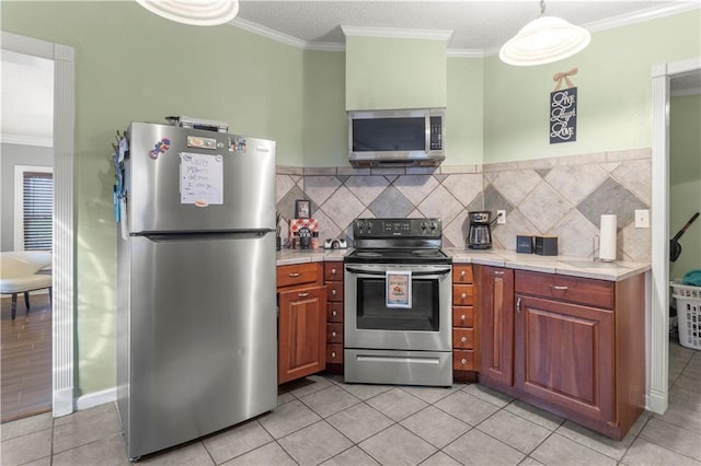 kitchen featuring backsplash, ornamental molding, hanging light fixtures, and appliances with stainless steel finishes