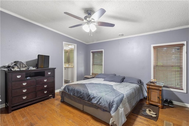 bedroom featuring connected bathroom, light wood-type flooring, ceiling fan, crown molding, and a textured ceiling