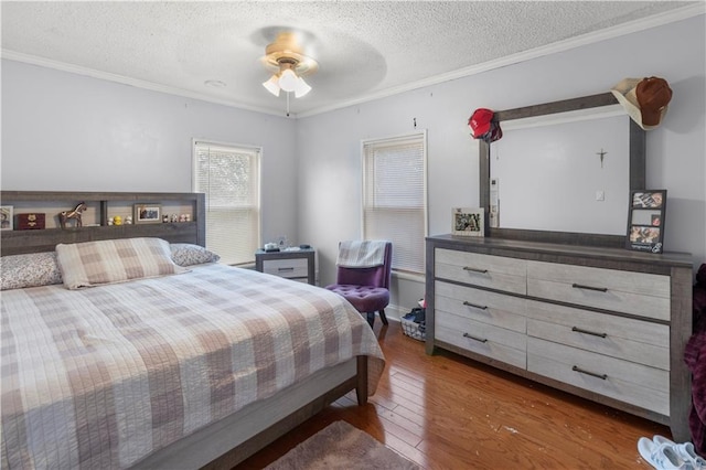 bedroom featuring crown molding, ceiling fan, wood-type flooring, and a textured ceiling