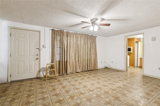 empty room with a textured ceiling and ceiling fan