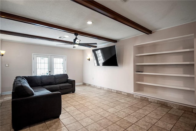 living room with a textured ceiling, beamed ceiling, light tile patterned floors, ceiling fan, and built in features