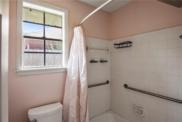 bathroom featuring toilet and shower / bathtub combination with curtain