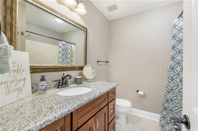 bathroom featuring tile patterned flooring, vanity, and toilet